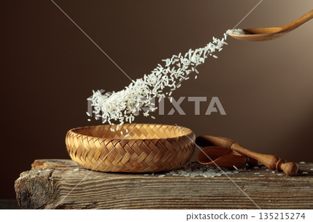 Rice is poured into a wicker bowl. 135215274