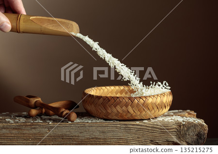Rice is poured into a wicker bowl. Rice is poured into a wicker bowl. 135215275