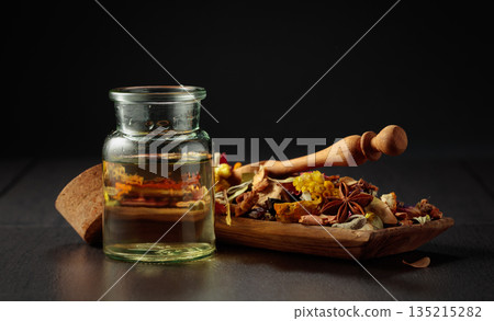 Essential oil or herbal tincture in a glass bottle. 135215282