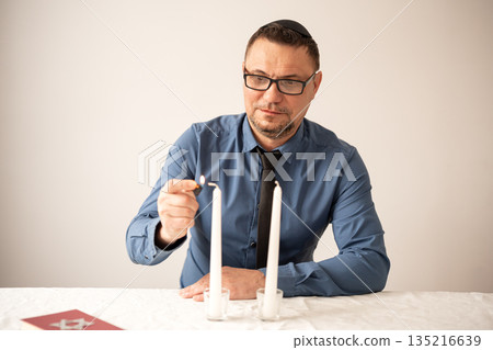 Jewish man lighting Shabbat candles. Shabbat Shalom. Jewish man lighting Shabbat candles. Shabbat Shalom. 135216639