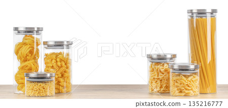 Assorted dry pasta stored in transparent glass jars on wooden table isolated on white background with copy space Assorted dry pasta stored in transparent glass jars on wooden table isolated on white background with copy space 135216777
