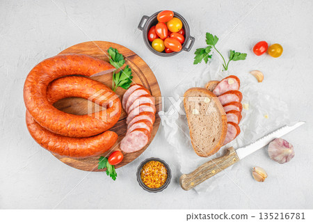 Smoked sausage with bread, mustard and tomatoes on light background, top view with copy space Smoked sausage with bread, mustard and tomatoes on light background, top view with copy space 135216781