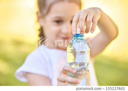 Hispanic female child opening water bottle in sunny outdoor setting with focus Hispanic female child opening water bottle in sunny outdoor setting with focus 135217602