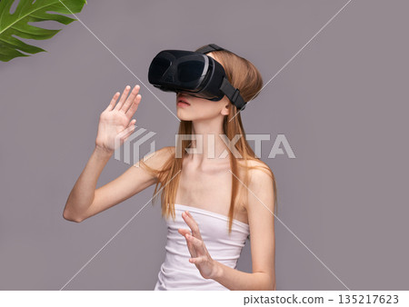 Young caucasian female engaging with virtual reality technology using vr headset Young caucasian female engaging with virtual reality technology using vr headset 135217623