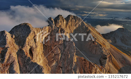 Amazing rocky mountains in clouds at sunset Amazing rocky mountains in clouds at sunset 135217672