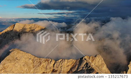 Amazing rocky mountains in clouds at sunset 135217673