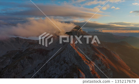 Amazing rocky mountains in clouds at sunset 135217679