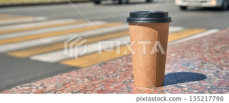 Disposable coffee cup on granite table near city crosswalk with passing Disposable coffee cup on granite table near city crosswalk with passing 135217798