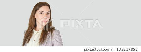 Confident caucasian female young adult in business attire against light grey 135217852