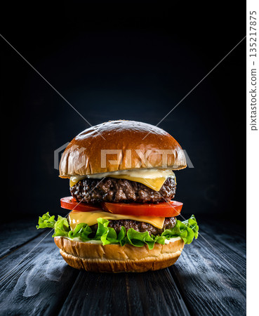 Stylized close-up of a burger with fresh lettuce, tomato, and cheese on a wooden surface against a dark background Stylized close-up of a burger with fresh lettuce, tomato, and cheese on a wooden surface against a dark background 135217875