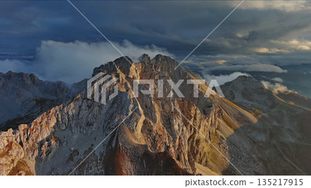 Amazing rocky mountains in clouds at sunset Amazing rocky mountains in clouds at sunset 135217915