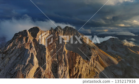 Amazing rocky mountains in clouds at sunset Amazing rocky mountains in clouds at sunset 135217916