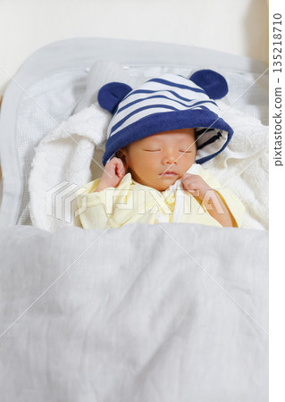One-month-old newborn baby sleeping with a hat on_Vertical 135218710