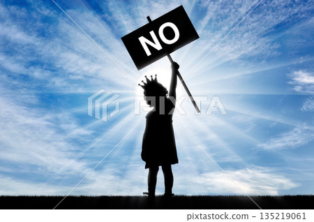 Girl child egoist with a crown on his head holds a poster with the word no. 135219061