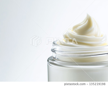 Creamy skincare product in clear jar showcasing luxurious texture and elegant presentation with copy space 135219198