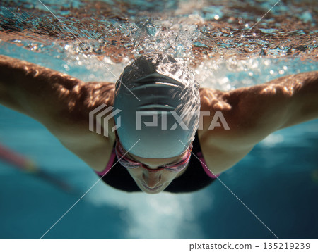Swimmer diving into clear water, showcasing powerful strokes and dynamic movement in aquatic environment Swimmer diving into clear water, showcasing powerful strokes and dynamic movement in aquatic environment 135219239