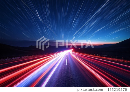 Glowing red and white light trails crossing dark road under starry night sky Glowing red and white light trails crossing dark road under starry night sky 135219276