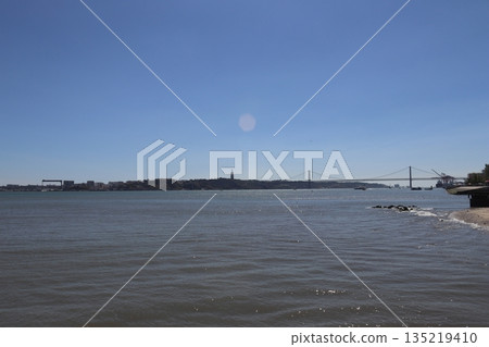 Panoramic view of the Tagus River with the 25 de Abril Bridge and Cristo Rei monument in Lisbon, Portugal 135219410