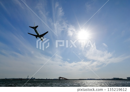 Strong sunlight and the shadow of a landing plane Strong sunlight and the shadow of a landing plane 135219612