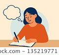 Woman happily writing at desk with notebook 135219771