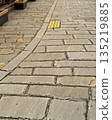 Stone-paved walking path with tactile paving 135219885