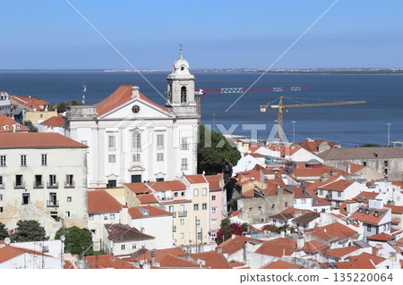 The Church of Santo Estevao overlooking traditional Alfama rooftops and the Tagus River in Lisbon, Portugal The Church of Santo Estevao overlooking traditional Alfama rooftops and the Tagus River in Lisbon, Portugal 135220064