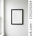 Blank picture frame on white wall in minimalist interior 135220264