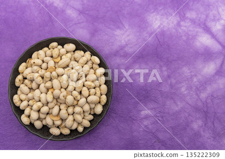 烤黃豆盛於紫色和紙上,置於黑色盤子中。 烤黃豆盛於紫色和紙上,置於黑色盤子中。 135222309