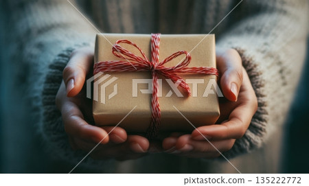 Gift wrapped in brown paper presented with care, showcasing a thoughtful gesture during a special occasion Gift wrapped in brown paper presented with care, showcasing a thoughtful gesture during a special occasion 135222772