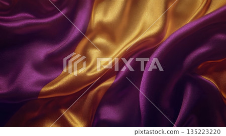 Vibrant purple and gold fabric flowing smoothly in natural light creates a luxurious ambiance in a textiles studio 135223220