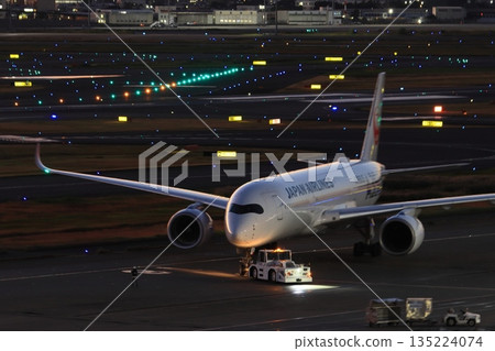 一架客機被拖走，準備執行夜間飛行任務。 135224074