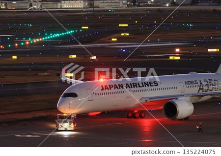 一架客機被拖走，準備執行夜間飛行任務。 135224075