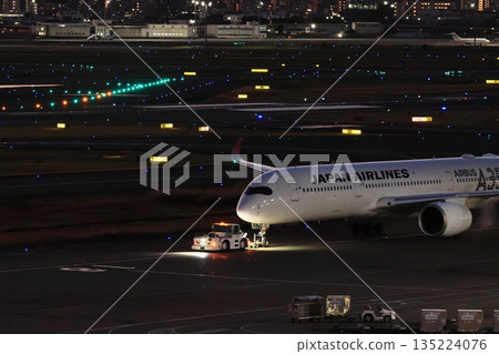 一架客機被拖走,準備執行夜間飛行任務。 一架客機被拖走,準備執行夜間飛行任務。 135224076