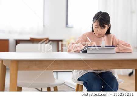 Elementary school girl learning on a tablet Elementary school girl learning on a tablet 135225231