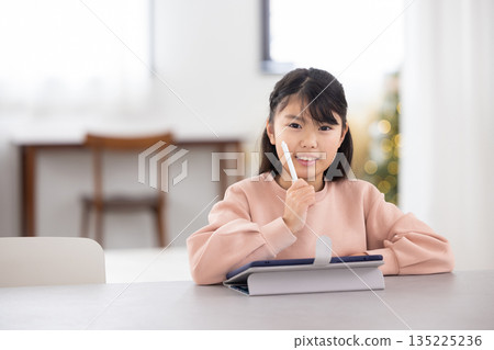 小學生女孩一邊用平板電腦學習一邊微笑 135225236