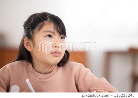 小學生女孩一邊用平板電腦學習一邊微笑 135225243