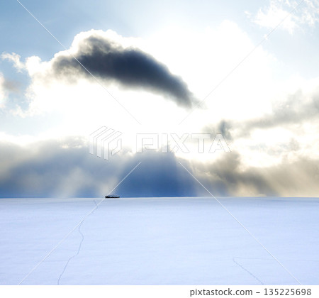 冬日的夕陽灑在北海道美瑛白雪皚皚的田野上,陽光從雲層中傾瀉而下。 冬日的夕陽灑在北海道美瑛白雪皚皚的田野上,陽光從雲層中傾瀉而下。 135225698