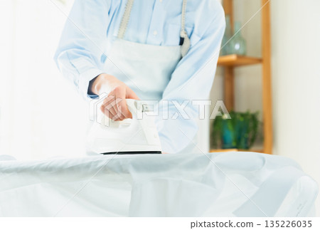 女人熨燙襯衫的手 女人熨燙襯衫的手 135226035