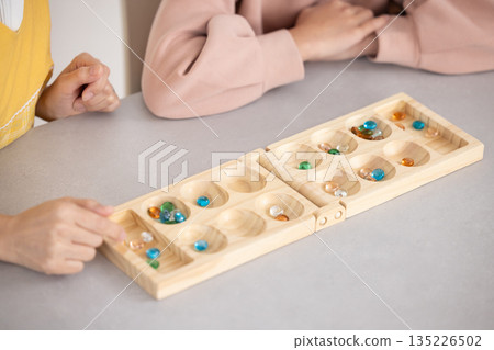 父母與孩子玩曼卡拉棋的特寫鏡頭 135226502