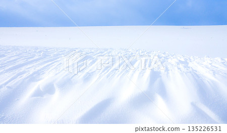 Wind patterns on the snowfields are a common sight in windy Hokkaido in mid-winter. Wind patterns on the snowfields are a common sight in windy Hokkaido in mid-winter. 135226531