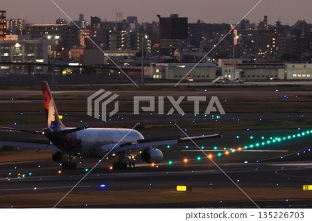 Passenger plane heading for a night flight Passenger plane and guide lights 135226703