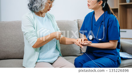 Asian nurse providing home healthcare to elderly woman. Professional caregiver offering senior care, medical consultation, compassion Asian nurse providing home healthcare to elderly woman. Professional caregiver offering senior care, medical consultation, compassion 135226896