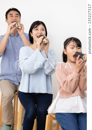 A family of three eating ehomaki whole 135227317