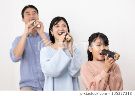 A family of three eating ehomaki whole 135227318