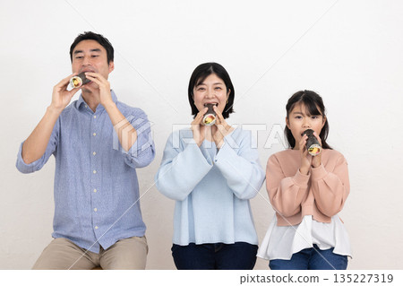 A family of three eating ehomaki whole A family of three eating ehomaki whole 135227319