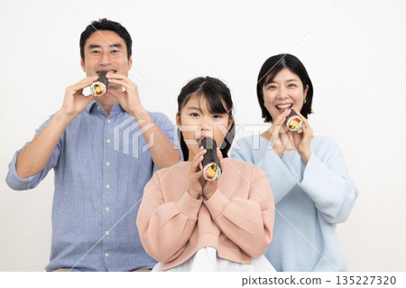A family of three eating ehomaki whole A family of three eating ehomaki whole 135227320