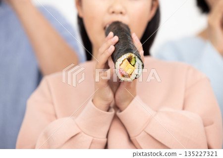 A family of three eating ehomaki whole A family of three eating ehomaki whole 135227321