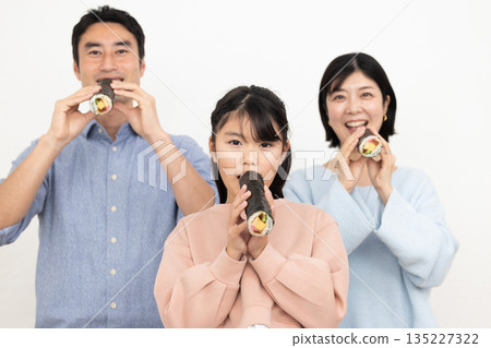 一家三口正在吃整根的江魚捲。 135227322