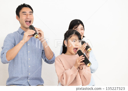 一家三口正在吃整根的江魚捲。 135227323