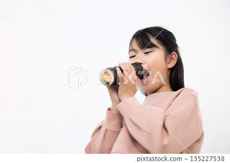 A girl eating a whole ehomaki 135227538